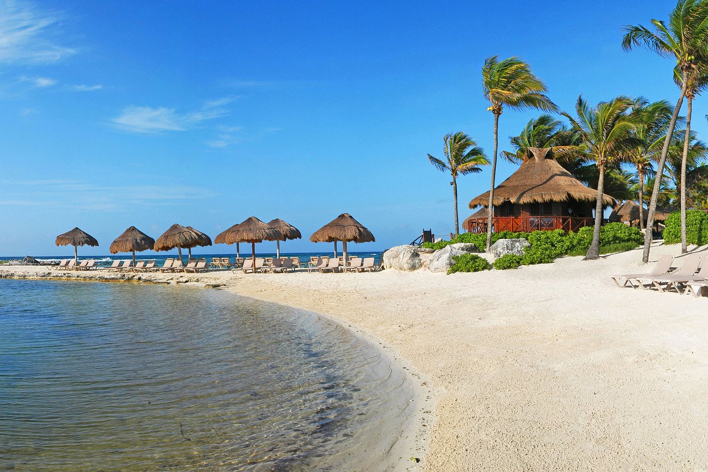 Beach with thatched palapas and turquoise water